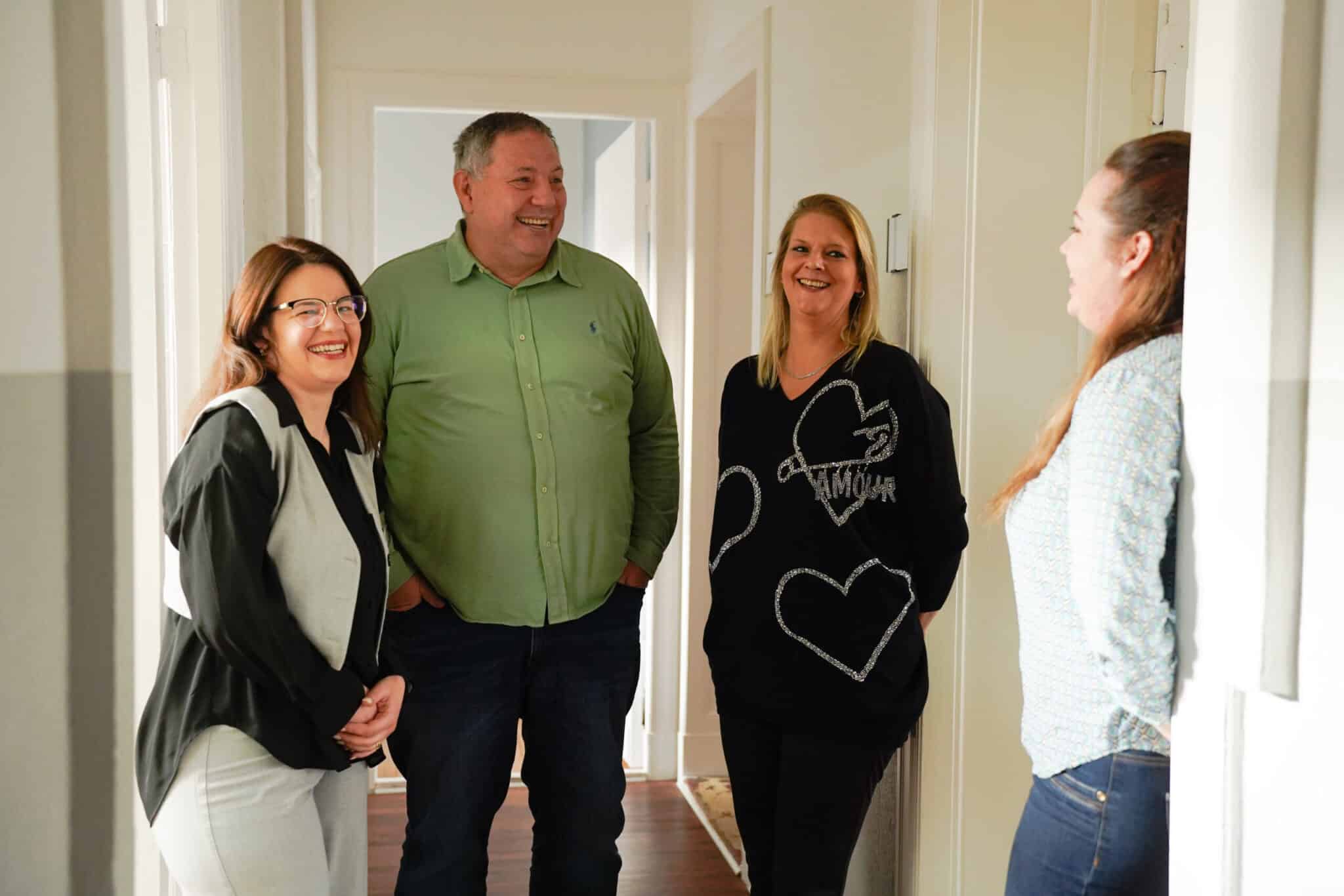 3 Frauen und ein Mann lächeln sich an